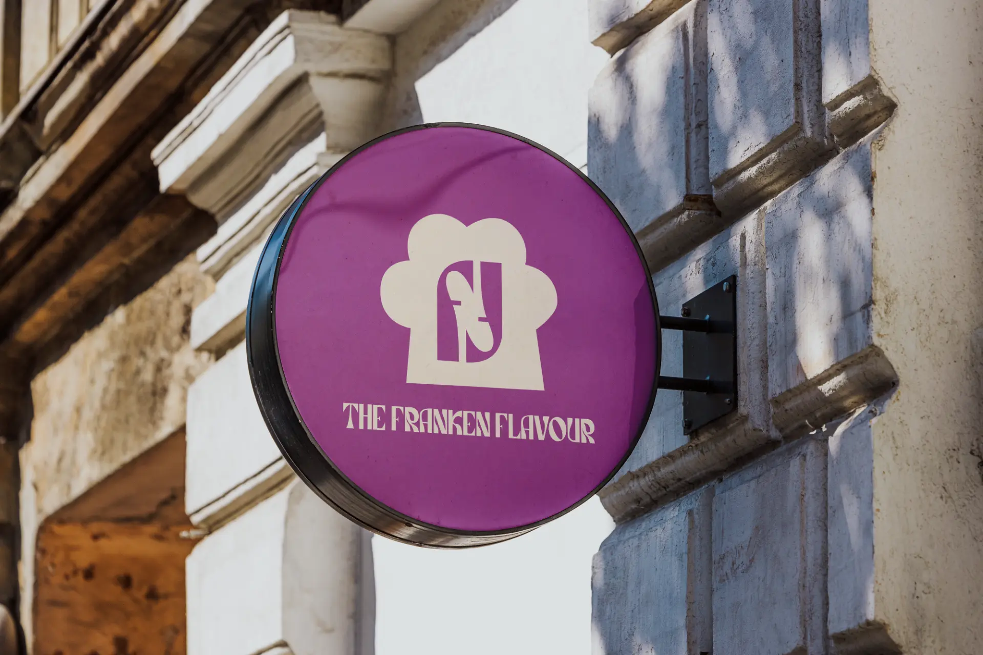 Round purple Franken Flavour blade sign mounted on a building exterior